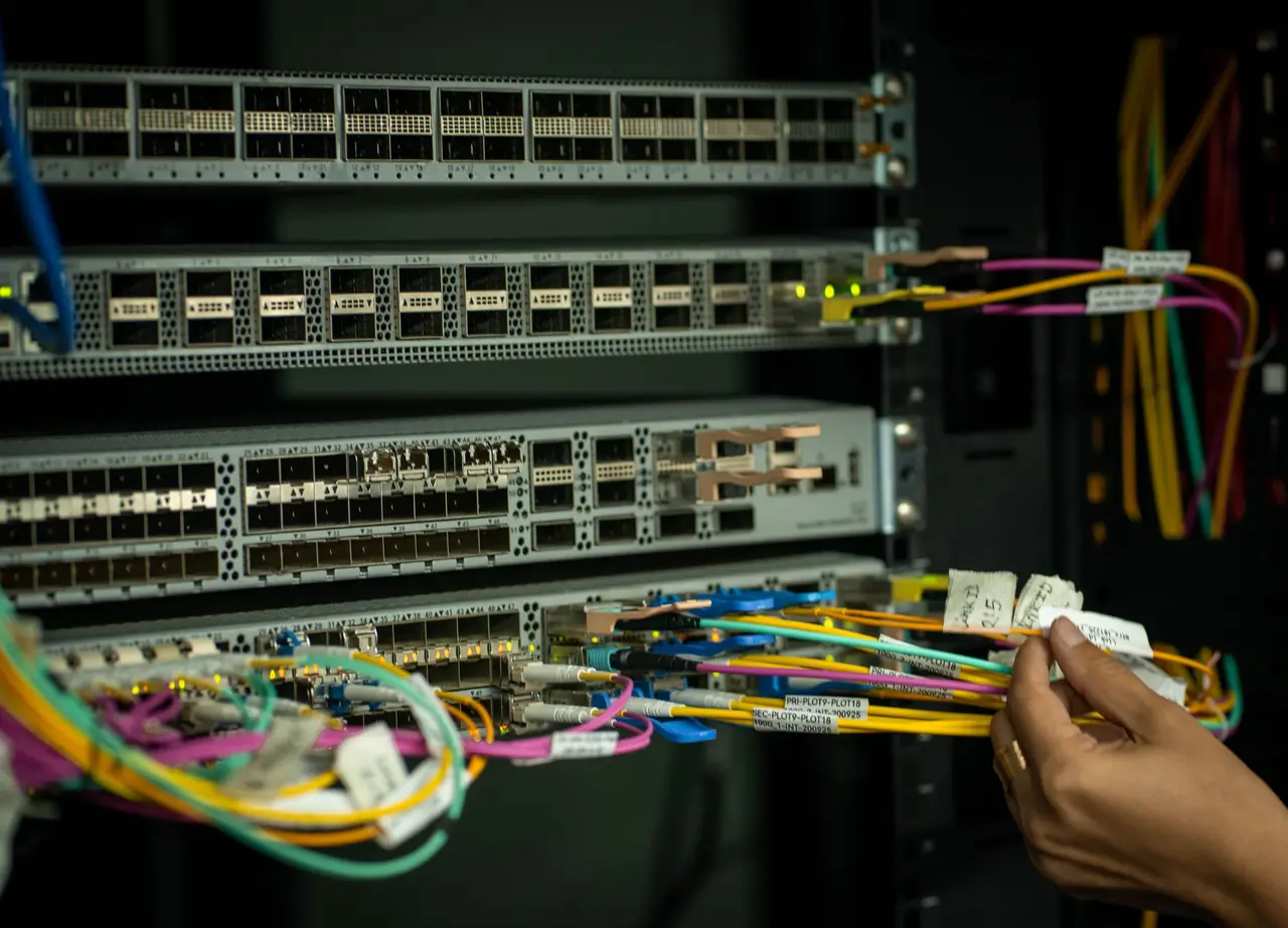 Técnico organizando cabos de rede em um rack